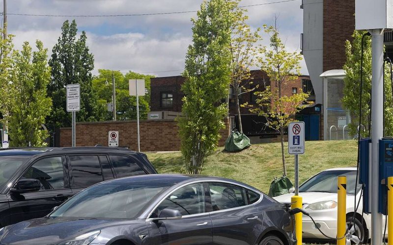White Tesla Model 3 charging at a station in Windsor, Ontario