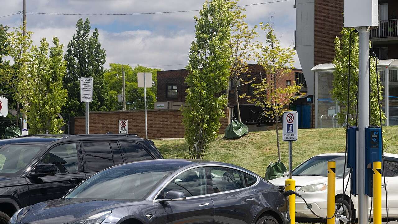 White Tesla Model 3 charging at a station in Windsor, Ontario