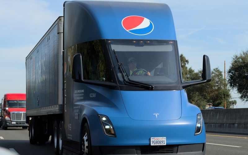 Blue Pepsi-branded Tesla Semi electric truck pulling a trailer on a highway