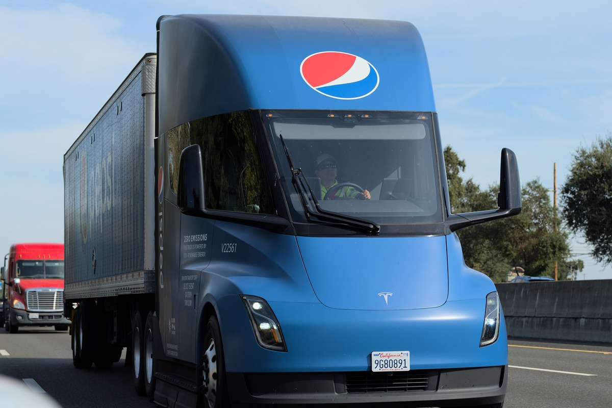 Blue Pepsi-branded Tesla Semi electric truck pulling a trailer on a highway