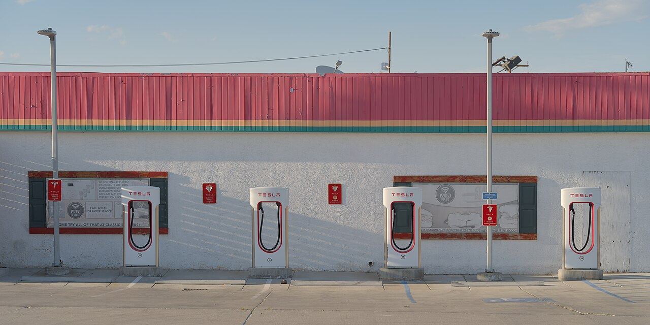 Tesla Supercharger stalls with charging cables at a station